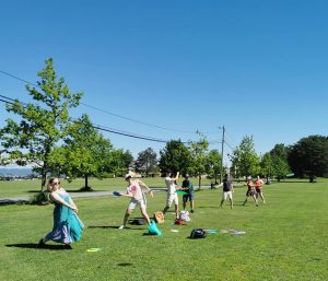 Koret står i en rad og trener å kaste frisbee på en gressplan